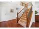An interior view showing a carpeted staircase with elegant dark wood banisters and beautiful hardwood floors at 111 Millstone Way, Canton, GA 30115