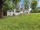 View of the rear exterior showing the yard, screen porch, and back of the home at 1110 Upper Hembree Rd, Roswell, GA 30076