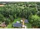 Aerial view highlighting home, backyard, mature trees, storage buildings, and surrounding neighborhood at 140 Wilbanks St, Buford, GA 30518