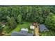 Aerial view of home's backyard showcasing mature trees, storage buildings, and plenty of open space at 140 Wilbanks St, Buford, GA 30518