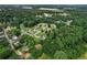 An aerial view shows homes among dense trees, creating a secluded and nature-filled residential area at 140 Wilbanks St, Buford, GA 30518