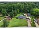 Aerial shot showcasing a property with a large, manicured lawn, detached garage, and ample parking at 140 Wilbanks St, Buford, GA 30518