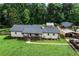 Exterior shot showing a ranch-style home with a covered porch, well-manicured lawn, and detached garage at 140 Wilbanks St, Buford, GA 30518