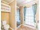 Bathroom featuring shower with glass doors, commode, and window with curtains at 143 Cotton Mill Dr, Hiram, GA 30141
