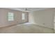 Bedroom features carpeted floors, ceiling fan, and two windows bringing in natural light at 143 Cotton Mill Dr, Hiram, GA 30141