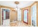 Charming dining area featuring a unique chandelier, tiled floor, and a red trimmed door to the sunroom at 143 Cotton Mill Dr, Hiram, GA 30141