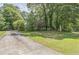 A beautiful home nestled among mature trees, showcasing a well-manicured lawn and a long driveway at 143 Cotton Mill Dr, Hiram, GA 30141