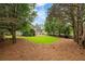 Expansive backyard with mature trees and lush lawn providing space for recreation and outdoor living at 6695 Buckingham Cir, Cumming, GA 30040