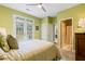 Bedroom with a ceiling fan, neutral walls, access to an ensuite bathroom, and a view of the backyard at 6695 Buckingham Cir, Cumming, GA 30040