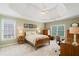 Bright bedroom with a trey ceiling, ceiling fan, and plush neutral carpeting at 6695 Buckingham Cir, Cumming, GA 30040