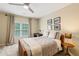 Cozy bedroom showcasing a ceiling fan, window with curtains, and a comfortable-looking bed at 6695 Buckingham Cir, Cumming, GA 30040