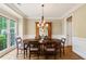 Elegant dining room featuring wood floors, a large window, and a decorative chandelier at 6695 Buckingham Cir, Cumming, GA 30040