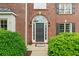Elegant entryway featuring a stylish front door, decorative sidelights, and manicured landscaping at 6695 Buckingham Cir, Cumming, GA 30040