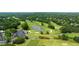 Scenic aerial view of the community golf course with trees, greens, and a clubhouse at 6695 Buckingham Cir, Cumming, GA 30040