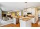 Bright kitchen with granite countertops, stainless appliances, and an island that opens to the living room with fireplace at 6695 Buckingham Cir, Cumming, GA 30040