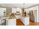 Charming kitchen with an island, granite counters, stainless steel appliances, and white cabinetry at 6695 Buckingham Cir, Cumming, GA 30040