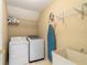 Functional laundry room with washer, dryer, utility sink, and shelving for organized storage at 6695 Buckingham Cir, Cumming, GA 30040