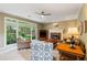 Comfortable living room featuring a brick fireplace, neutral decor, and large windows at 6695 Buckingham Cir, Cumming, GA 30040
