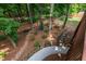 Lush backyard featuring mature trees, landscaped gardens, and a stone path at 9967 Devonshire St, Douglasville, GA 30135
