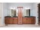 Bathroom featuring dual sink vanity with dark countertops and light wood cabinets with a central cabinet at 9967 Devonshire St, Douglasville, GA 30135