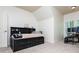 Bedroom with black bed with storage and desk next to window with shutters at 9967 Devonshire St, Douglasville, GA 30135