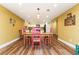 Dining room with pink chairs, wooden table, hardwood floors, and yellow walls at 9967 Devonshire St, Douglasville, GA 30135