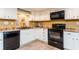 Kitchen with white cabinets, black appliances, tile floor, and yellow walls at 9967 Devonshire St, Douglasville, GA 30135