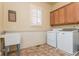 Laundry room featuring a utility sink, upper cabinets and modern washer and dryer at 9967 Devonshire St, Douglasville, GA 30135