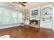 Inviting living room with a cozy brick fireplace, custom built-ins, and hardwood floors at 9967 Devonshire St, Douglasville, GA 30135