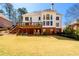 Expansive backyard view featuring a well-maintained lawn, a deck with outdoor seating, and a brick facade at 1105 River Laurel Dr, Suwanee, GA 30024