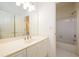 Bright bathroom features a white vanity, a large mirror, and a shower-tub combo with tiled walls at 1105 River Laurel Dr, Suwanee, GA 30024