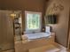 Tiled bathroom features a soaking tub and enclosed glass shower at 1105 River Laurel Dr, Suwanee, GA 30024