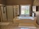 Tiled bathroom features a soaking tub and enclosed glass shower at 1105 River Laurel Dr, Suwanee, GA 30024