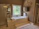 Bright bathroom with a soaking tub, separate shower, and stained glass window at 1105 River Laurel Dr, Suwanee, GA 30024
