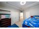 Bedroom with a tv, shelving and a bed with blue accents at 1105 River Laurel Dr, Suwanee, GA 30024