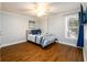 Bedroom with hardwood floors, natural lighting, blue accents, and a modern ceiling fan at 1105 River Laurel Dr, Suwanee, GA 30024