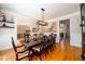 Formal dining room with hardwood floors, wainscoting, and modern lighting fixture above a large table at 1105 River Laurel Dr, Suwanee, GA 30024