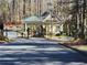 Community entrance gatehouse with stone accents and mature trees at 1105 River Laurel Dr, Suwanee, GA 30024