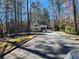 Neighborhood entrance with gatehouse, lush landscaping, and mature trees at 1105 River Laurel Dr, Suwanee, GA 30024