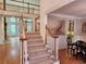 Inviting entryway with carpeted stairs, light wood railings, and a view to the open living room with bright windows at 1105 River Laurel Dr, Suwanee, GA 30024