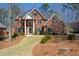 Charming two-story brick home with a well-maintained lawn and mature trees surrounding the property at 1105 River Laurel Dr, Suwanee, GA 30024