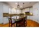 Bright kitchen features an island with granite countertops, white cabinets, and modern pendant lighting at 1105 River Laurel Dr, Suwanee, GA 30024