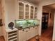Kitchen buffet with glass-front cabinets, granite counters, and storage shelves, adjacent to a dining room at 1105 River Laurel Dr, Suwanee, GA 30024