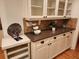 Kitchen buffet with granite countertop, decorative objects, and storage shelves, adjacent to a dining room at 1105 River Laurel Dr, Suwanee, GA 30024