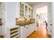 Kitchen buffet with glass-front cabinets, granite counters, and storage shelves, adjacent to the dining room at 1105 River Laurel Dr, Suwanee, GA 30024