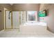 An elegant bathroom with a jetted tub, glass-enclosed shower, and decorative window at 1105 River Laurel Dr, Suwanee, GA 30024