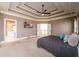 Main bedroom with a tray ceiling, ceiling fan, and access to an ensuite bathroom at 1105 River Laurel Dr, Suwanee, GA 30024