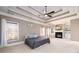 An expansive main bedroom featuring a tray ceiling, fireplace, built-ins, and windows at 1105 River Laurel Dr, Suwanee, GA 30024