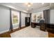Well-lit home office featuring a modern desk, large rug, and natural light from two windows at 1105 River Laurel Dr, Suwanee, GA 30024
