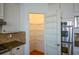 Pantry with ample shelving and door-mounted storage, located next to a stainless oven at 1105 River Laurel Dr, Suwanee, GA 30024